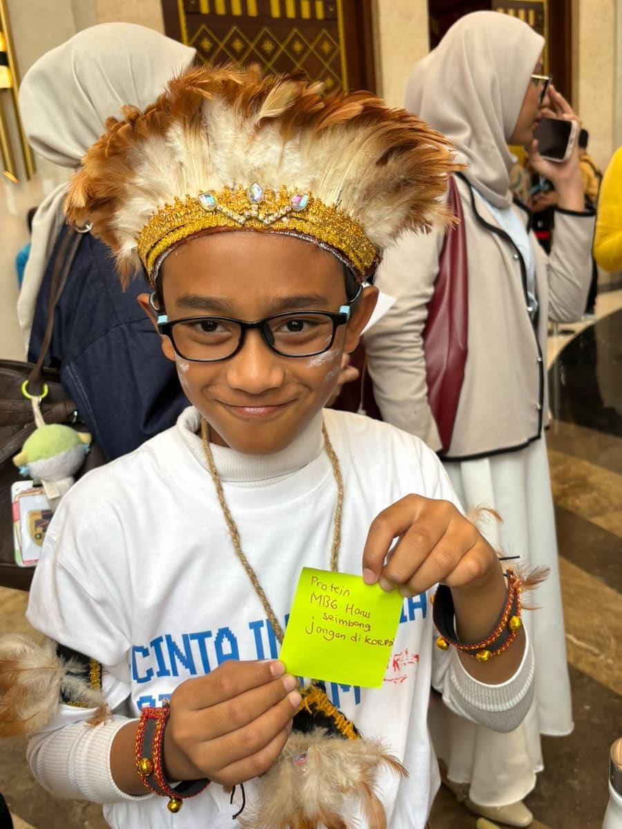A child in a feathered headdress at a Foodie Loka activity
